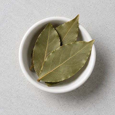 Dried bay leaves in a small white ramekin.