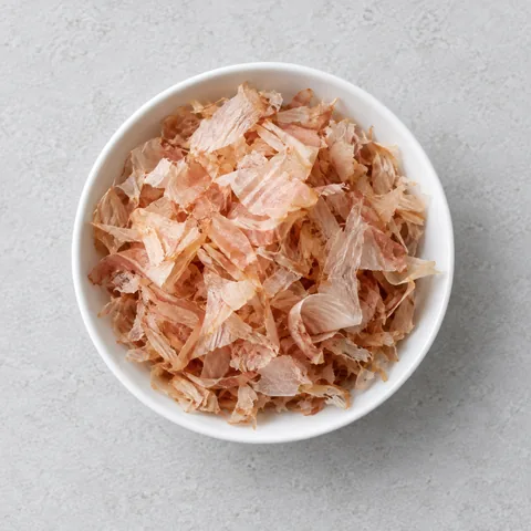 Dried bonito flakes (katsuobushi) in a small white bowl.