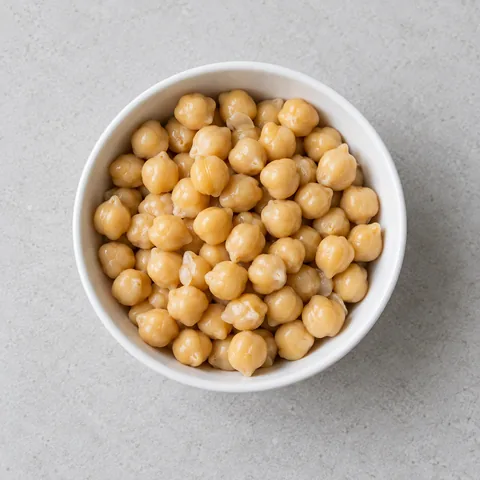 Canned chickpeas, drained and rinsed in a small white bowl.