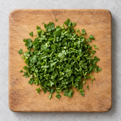 Chopped fresh cilantro on a wooden cutting board.