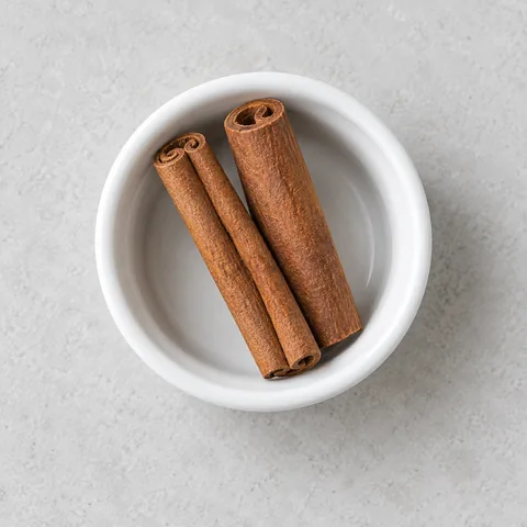 Cinnamon sticks in a small white ramekin.