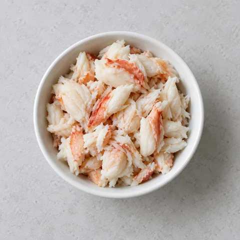 Cooked crabmeat in a small white bowl.