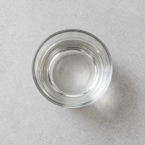 Distilled white vinegar in a small clear glass.
