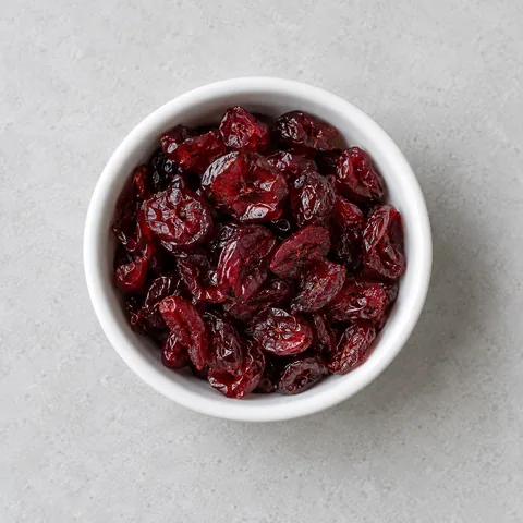 Sweetened dried cranberries in a small white ramekin.
