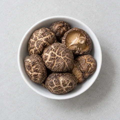 Dried shiitake mushrooms in a small white bowl.