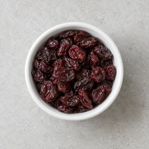 Dried tart cherries in a small white ramekin.