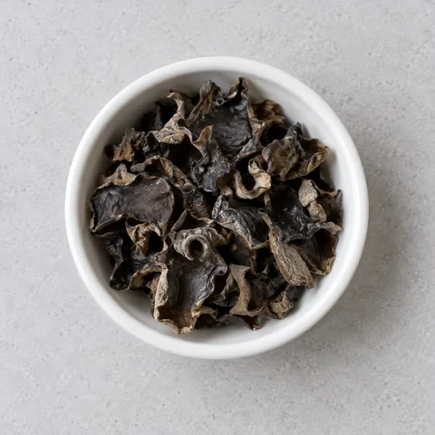 Dried wood ear mushroom pieces in a small white ramekin.