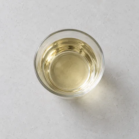 Dry white wine in a small clear glass.
