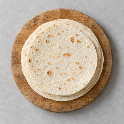 Flour tortillas on a wooden cutting board.
