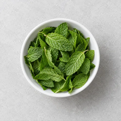 Fresh mint leaves in a small white bowl.
