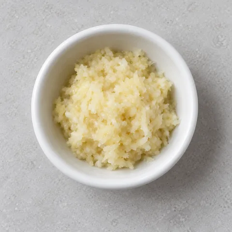 Finely grated garlic in a small white ramekin.