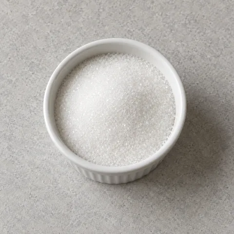 Granulated white sugar in a white bowl.