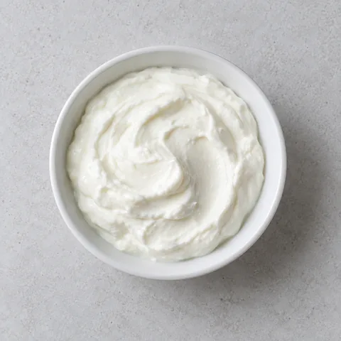 Plain whole-milk Greek yogurt in a small white bowl.