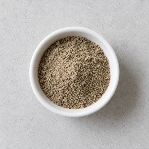 Ground cardamom in a small white ramekin.