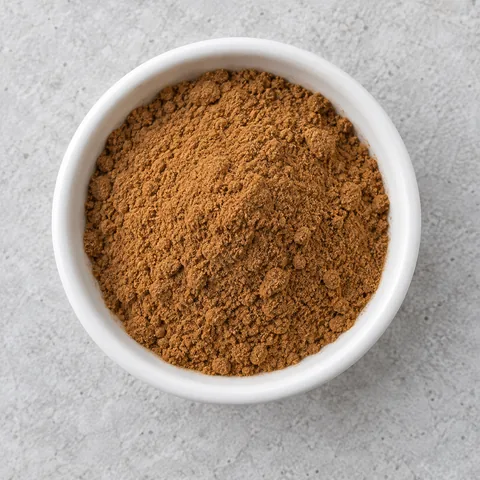 Ground cinnamon in a small white ramekin.