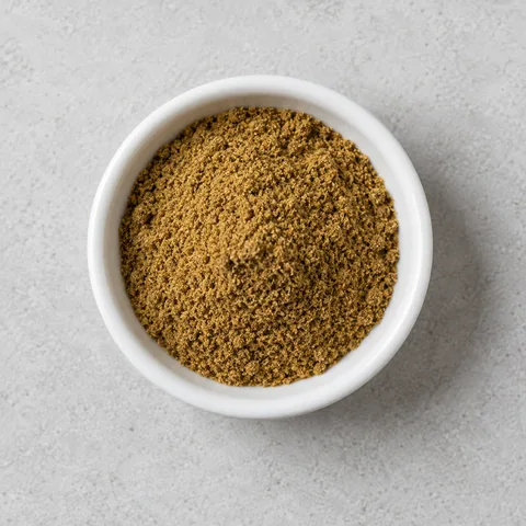 Ground cumin in a small white ramekin.