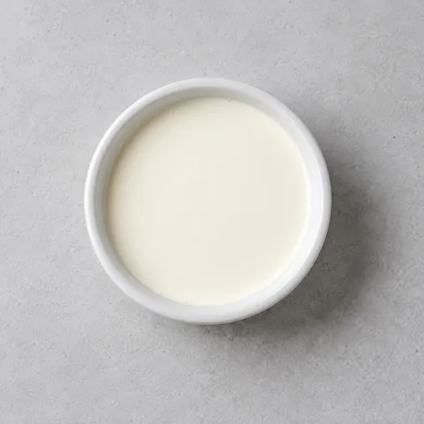 Heavy cream in a small white ramekin.