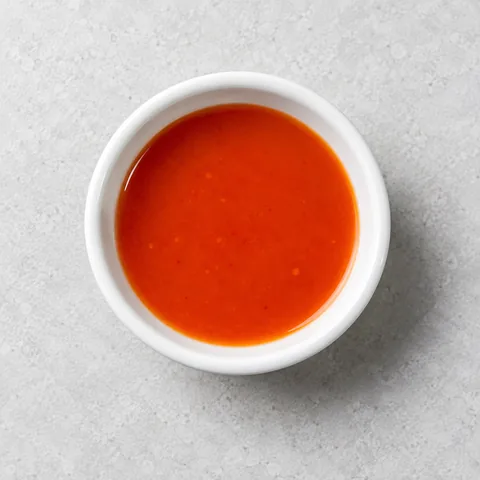 Hot pepper sauce in a small white ramekin.