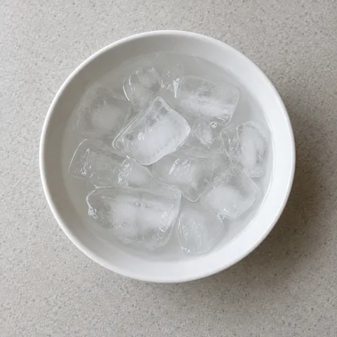 Water ice cubes in a white bowl.
