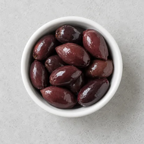 Kalamata olives in a small white ramekin.