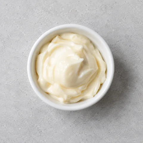 Mayonnaise in a small white ramekin.