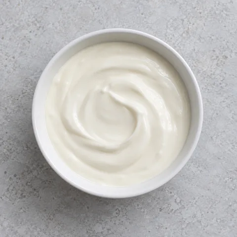 Mexican crema spooned into a small white bowl.