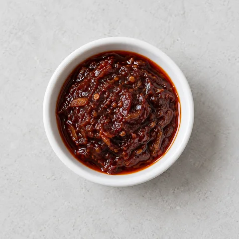 Thai roasted chili paste (nam prik pao) in a small white ramekin.