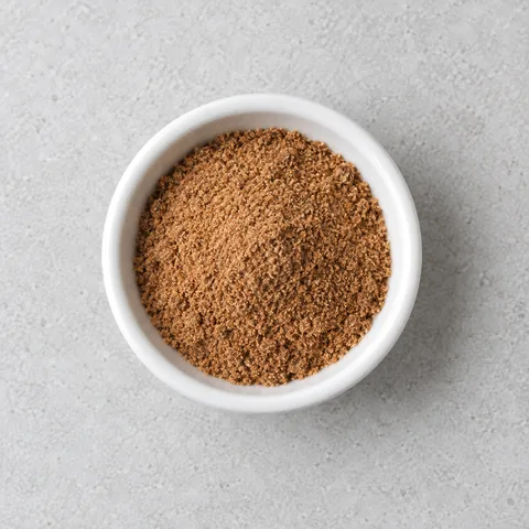 Ground nutmeg in a small white ramekin.