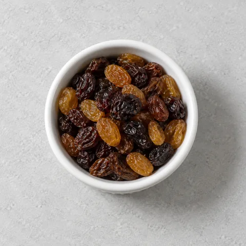 Raisins in a small white ramekin.
