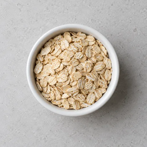 Old-fashioned rolled oats in a small white ramekin.