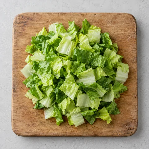Chopped romaine lettuce on a wooden cutting board.