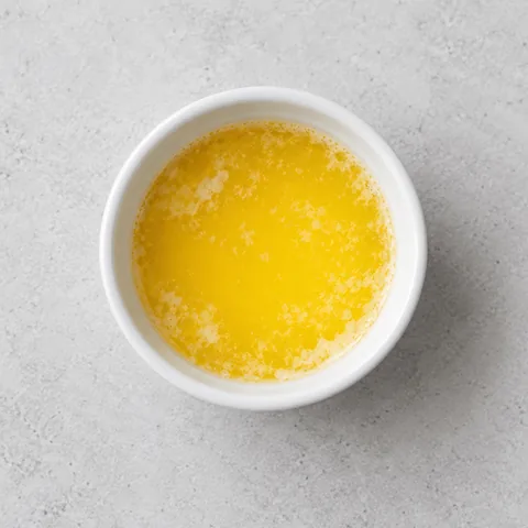 Melted salted butter in a small white ramekin.