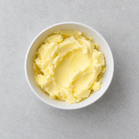 Softened salted butter in a small white bowl.