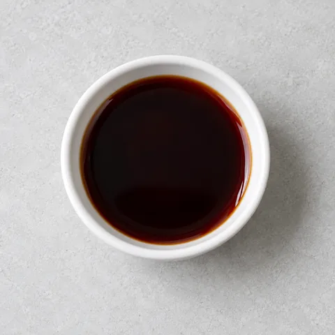 Soy sauce in a small white ramekin.