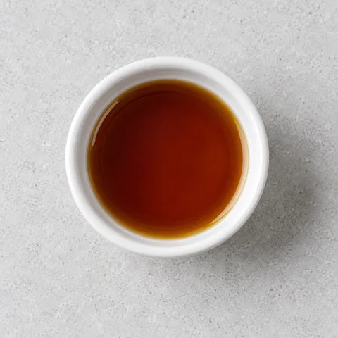 Toasted sesame oil in a small white ramekin.
