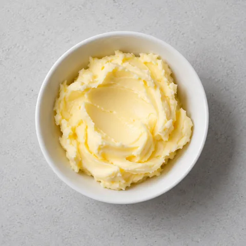 Softened unsalted butter in a small white bowl.