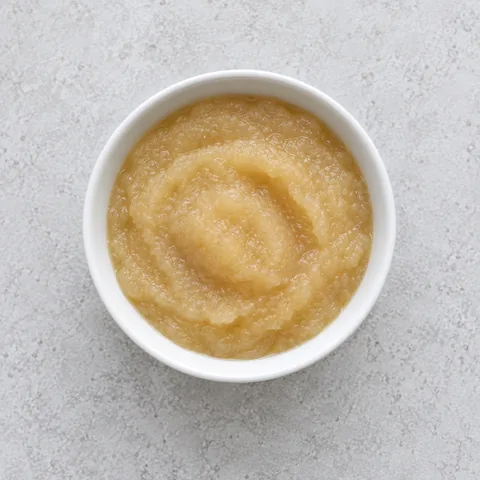 Unsweetened applesauce purée in a small white bowl.