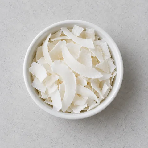 Unsweetened coconut flakes in a small white ramekin.