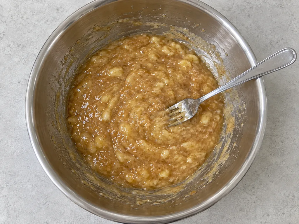 Mash the bananas. Keep stirring until the sugar no longer feels gritty against the bowl.