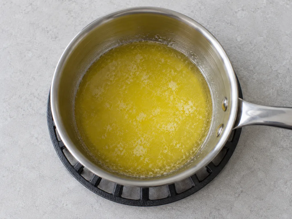 Melt the butter. Melt the butter in the small saucepan over low heat, then take the pan off the heat and let the butter cool until it is liquid and just warm to the touch.