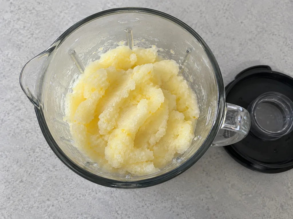 Thick spoonable lemon slush in a stopped blender jar, with its lid beside it.